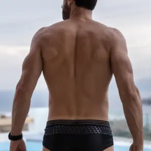 Mini pant noir brillant avec ceinture en résille, vue arrière, mettant en valeur un look sexy et audacieux.